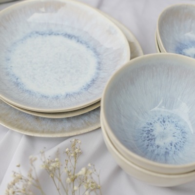 Conjunto de pratos e taças em cerâmica azul e branca com flores secas