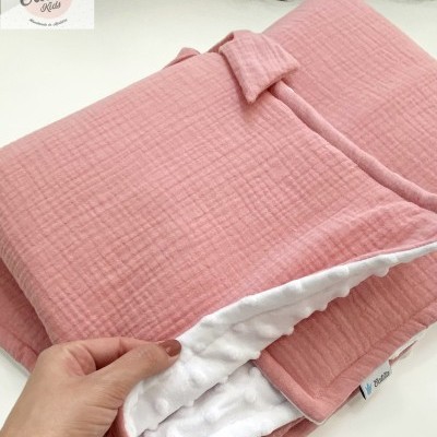 Colcha e almofada rosa com interior branco e textura em mesa branca
