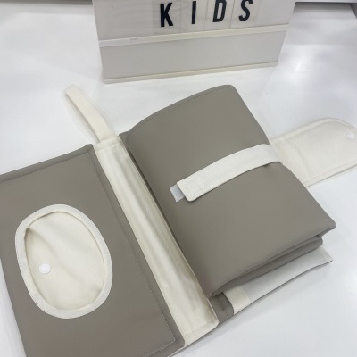 Capa dobrável cinzenta clara com interior branco e texto 'CATITA KIDS' em placa ao fundo