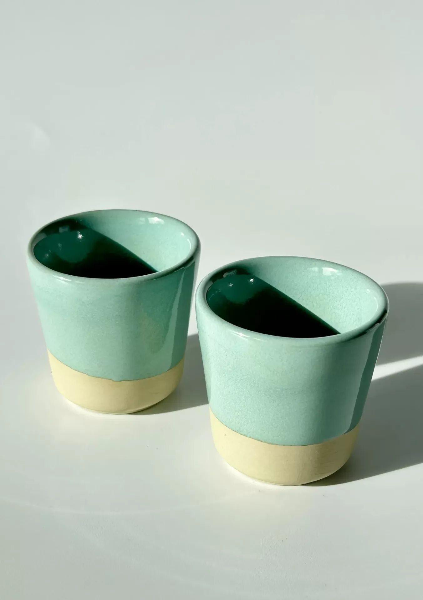 Duas chávenas cerâmicas verde água com base bege natural