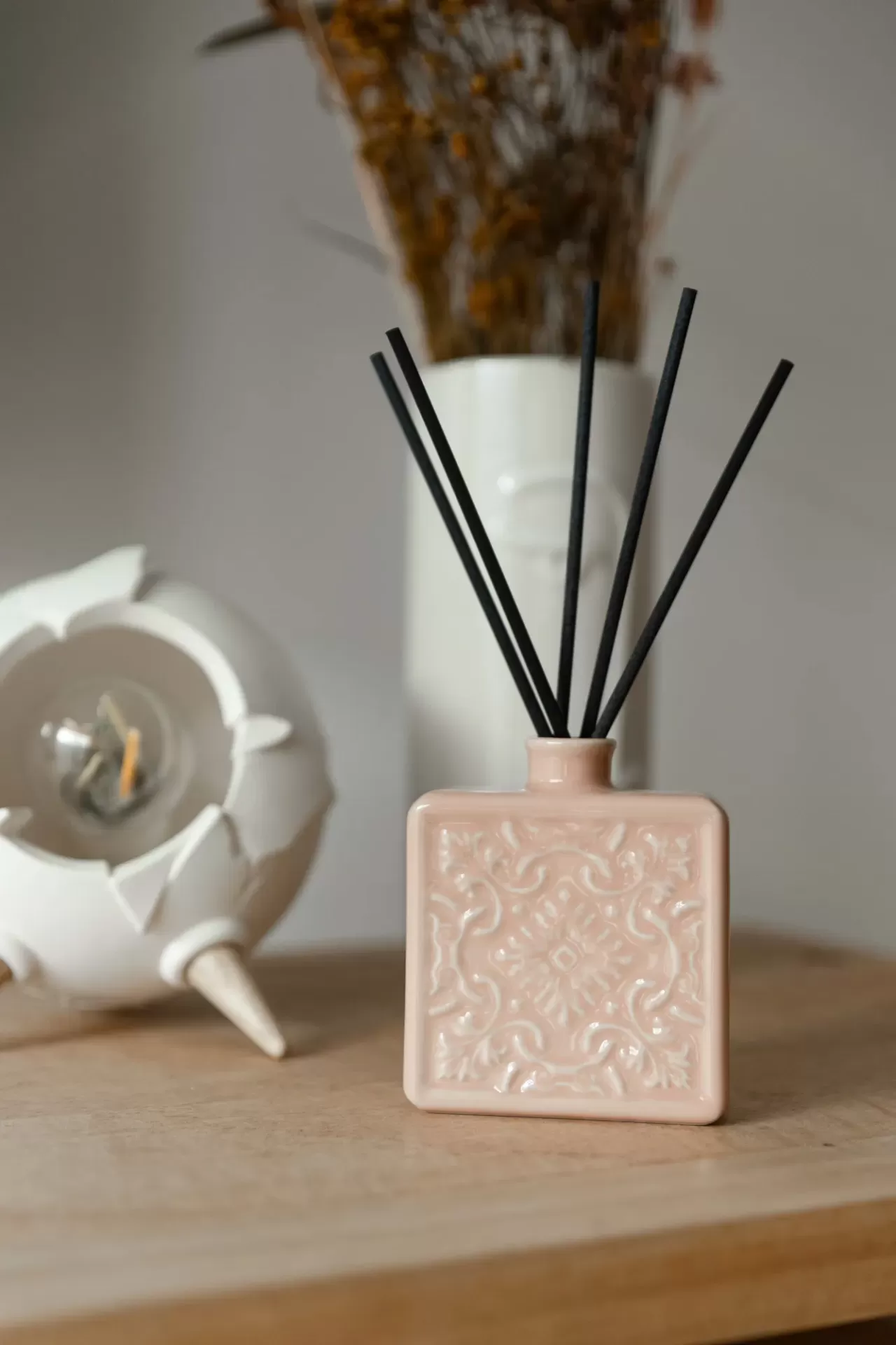 Vaso difusor de aromas quadrado em cerâmica rosa claro com padrão decorativo e varetas pretas