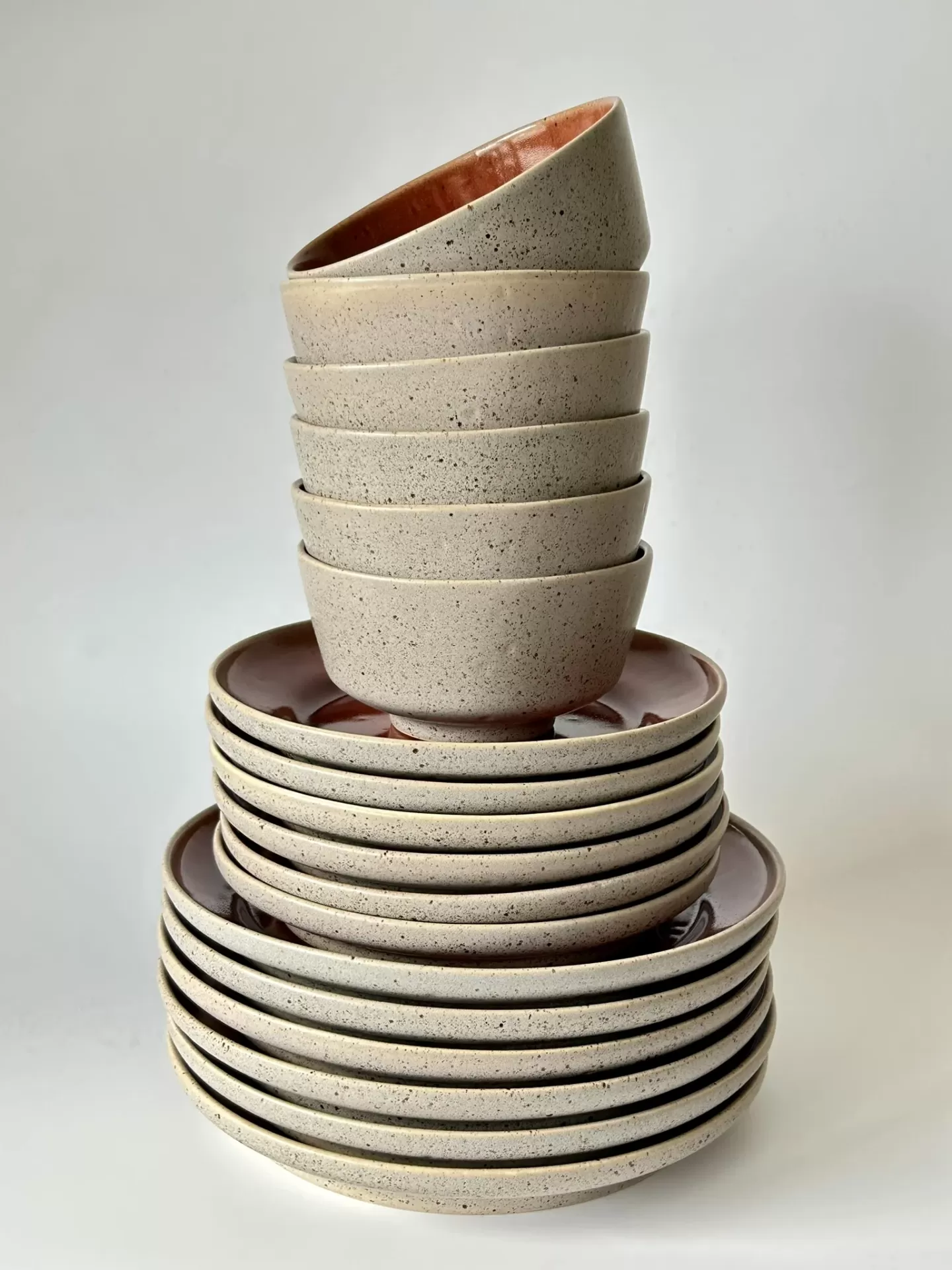 Conjunto empilhado de tigelas e pratos de cerâmica com textura pontilhada