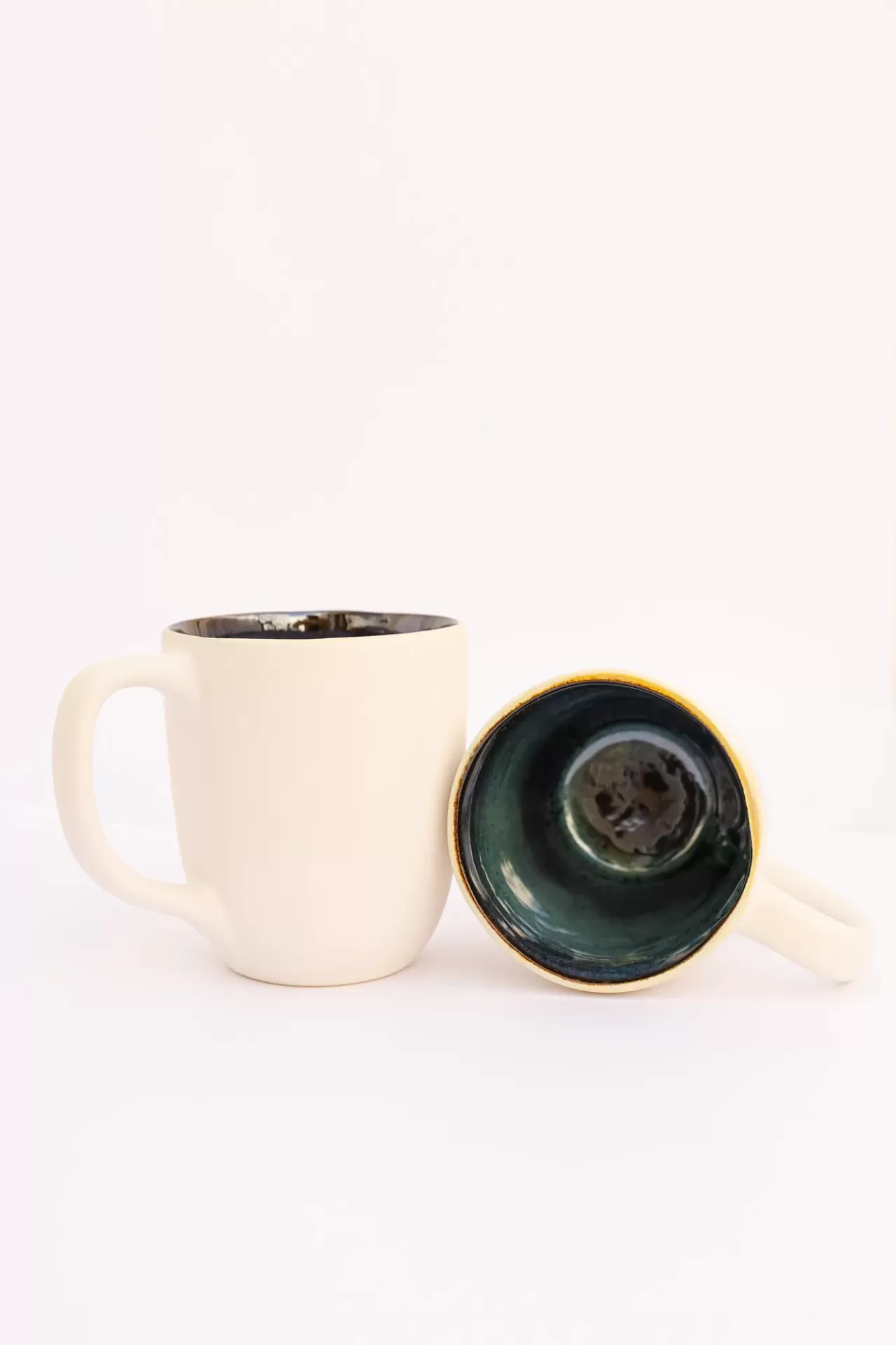 Conjunto de duas canecas cerâmicas creme com interior verde escuro e borda amarela