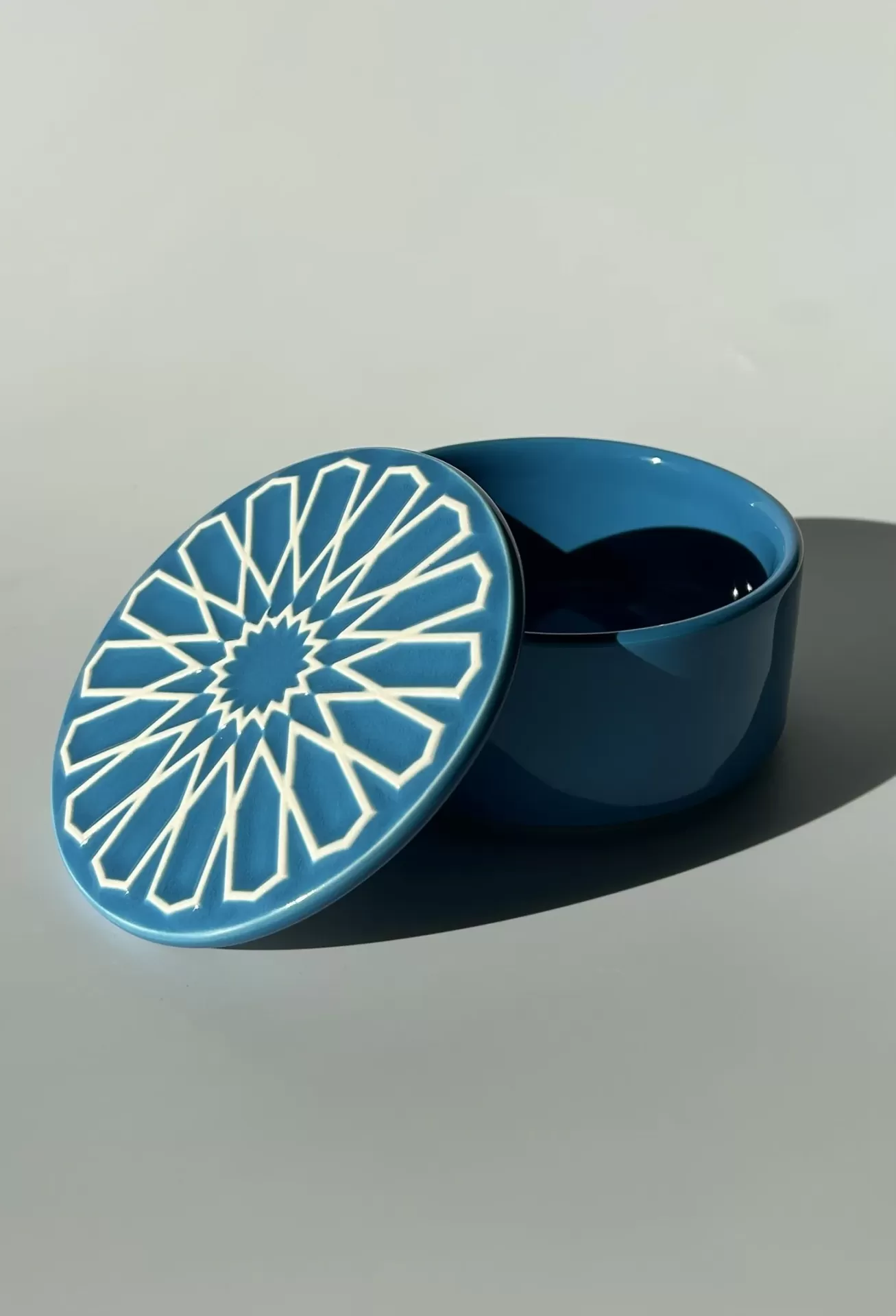 Caixa redonda azul em cerâmica com tampa decorada por padrão branco