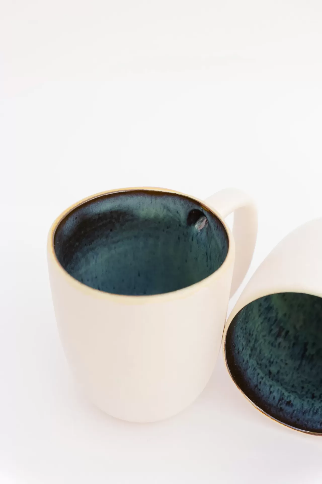 Duas canecas de cerâmica branca com interior azul escuro
