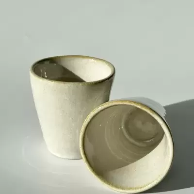 Duas chávenas de cerâmica bege claro com acabamento mate e bordas ligeiramente mais escuras