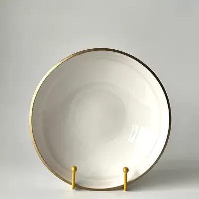 Prato branco com borda dourada numa base amarela