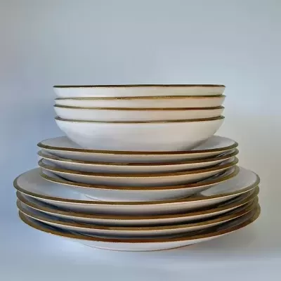 Conjunto de pratos brancos com borda dourada empilhados