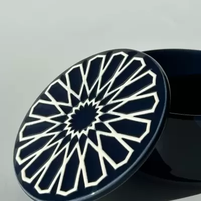 Tampa cerâmica azul escura com padrão branco em relevo