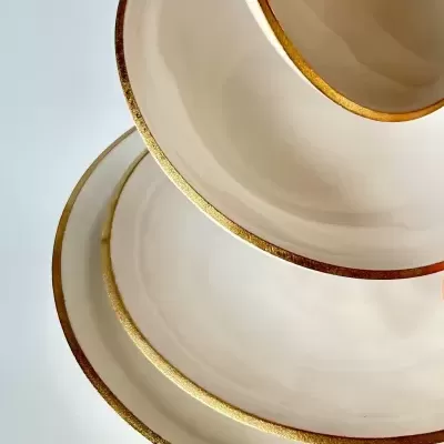 Conjunto de pratos bege com bordas douradas