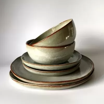 Conjunto de loiça em cerâmica cinzento esverdeado com bordas castanhas empilhado