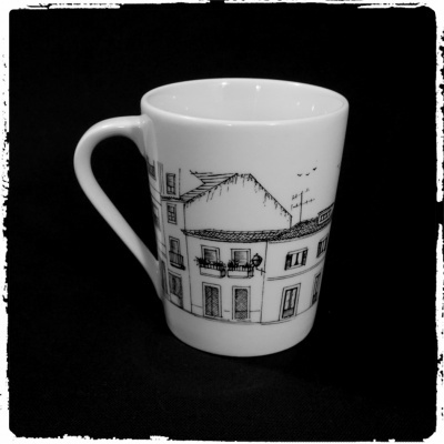 Caneca branca com desenho a preto de edifícios tradicionais