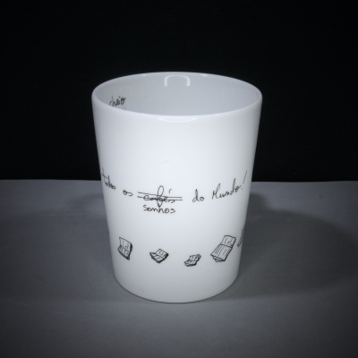 Caneca branca de cerâmica com texto e desenhos de livros.