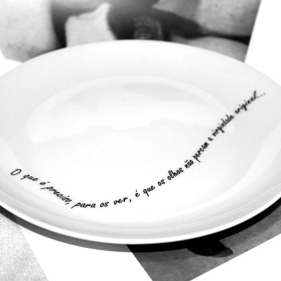 Prato branco redondo com frase escrita em preto na borda