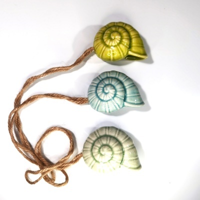 Ornamentos de concha em cerâmica vidrada com corda de juta.