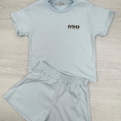 Conjunto de roupa azul claro com t-shirt e calção com detalhes brilhantes e texto 'mio'