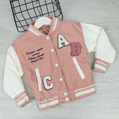 Casaco infantil bomber rosa com mangas brancas, letras aplicadas e texto bordado, sobre cabide e fundo de madeira clara