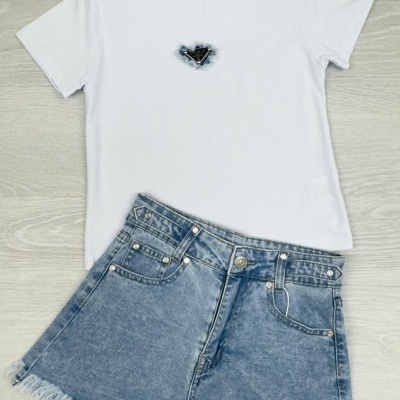 T-shirt branca com coração azul e calções de ganga azul claro com bainha desfiada