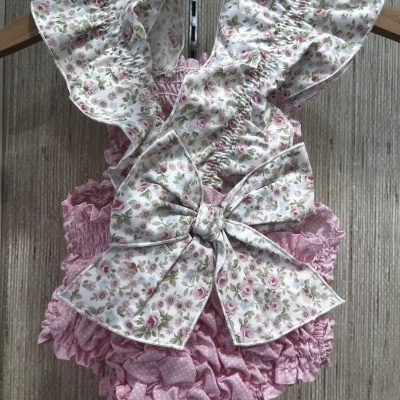 Macacão de bebé cor-de-rosa e branco com padrões florais e folhos