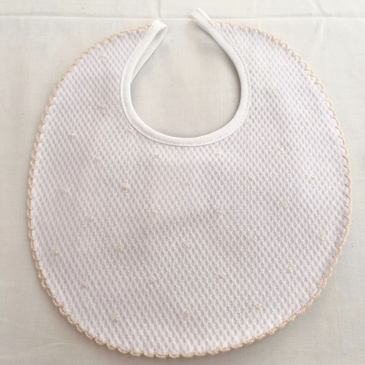 Babete de bebé branco com pequenos pontos creme e borda festonada creme