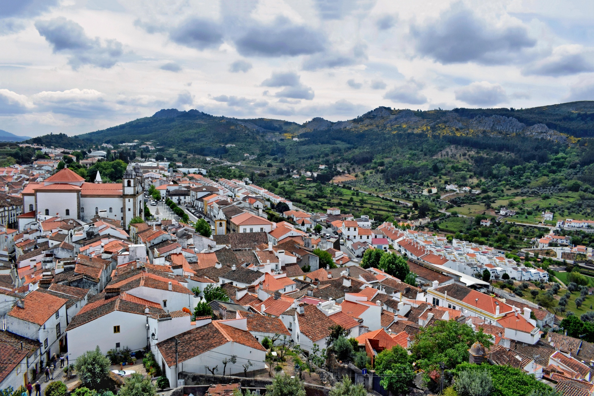 Marvão Autêntico: Fim de Semana com Voo, Alojamento Rural e Experiências Locais vila com casas brancas e telhados vermelhos com paisagem montanhosa verde
