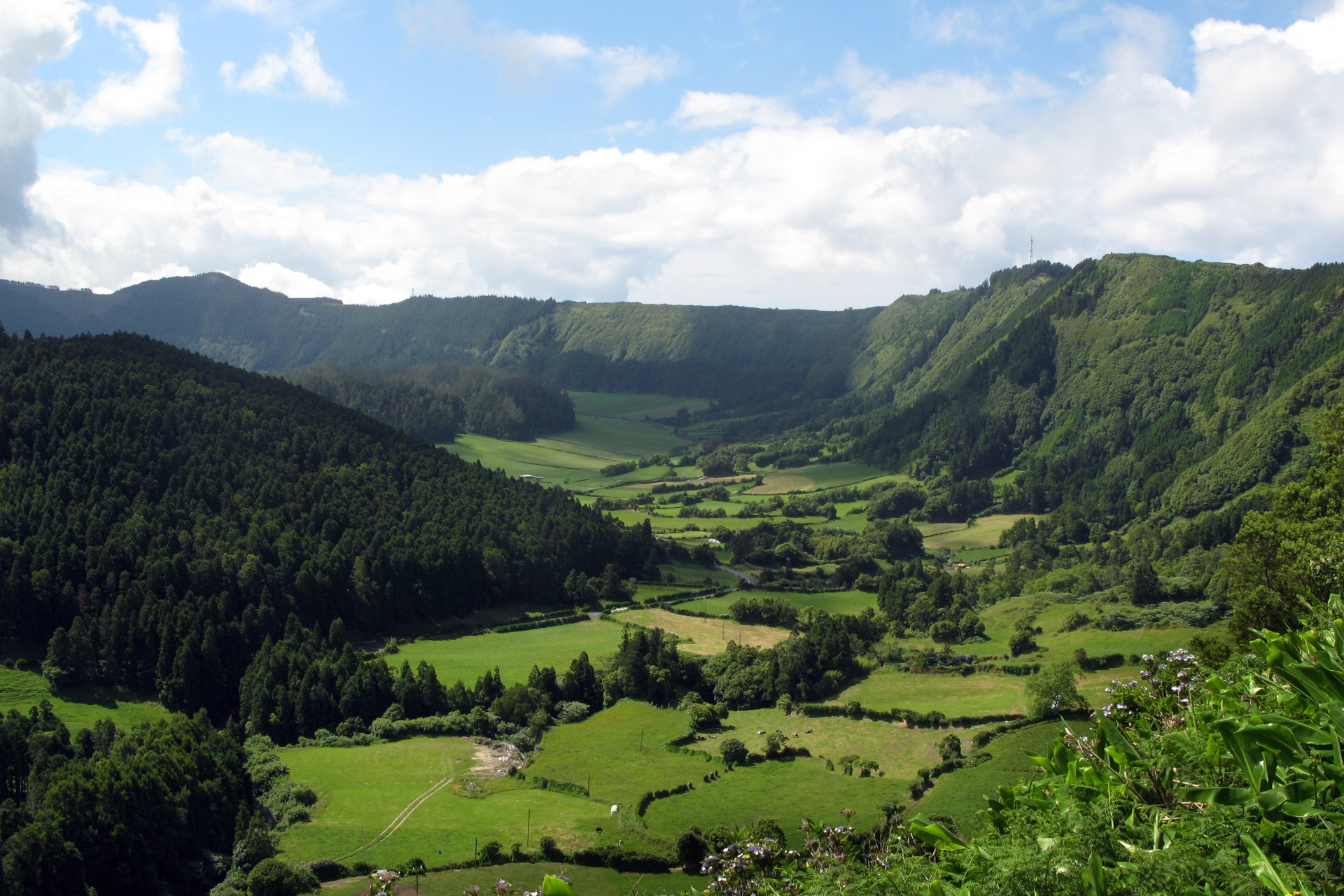 Açores – Nove Ilhas, Um Paraíso Inesquecível Vale verde com colinas e céu nublado