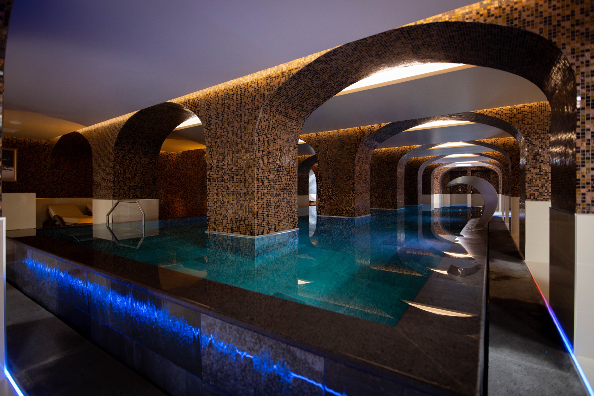 Açores – Nove Ilhas, Um Paraíso Inesquecível Piscina interior com colunas revestidas a azulejos e luzes LED azuis na borda.