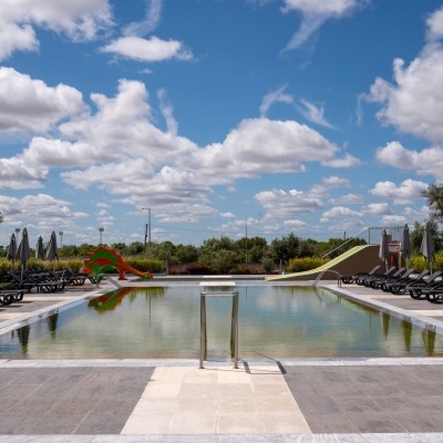 Piscina exterior com escorregas, espreguiçadeiras e guarda-sóis