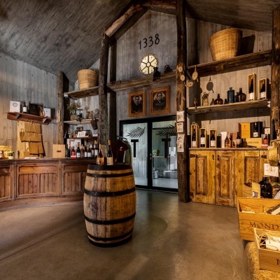 Loja rústica com móveis de madeira, barril, vinho e caixas de madeira MONDEGA