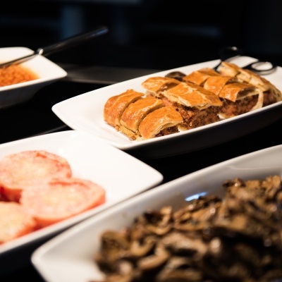 Quatro travessas brancas com diferentes alimentos: bolachas recheadas, cogumelos, tomate e feijão