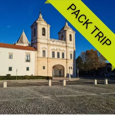 Edifício histórico com duas torres em pedra clara e faixa verde com texto PACK TRIP