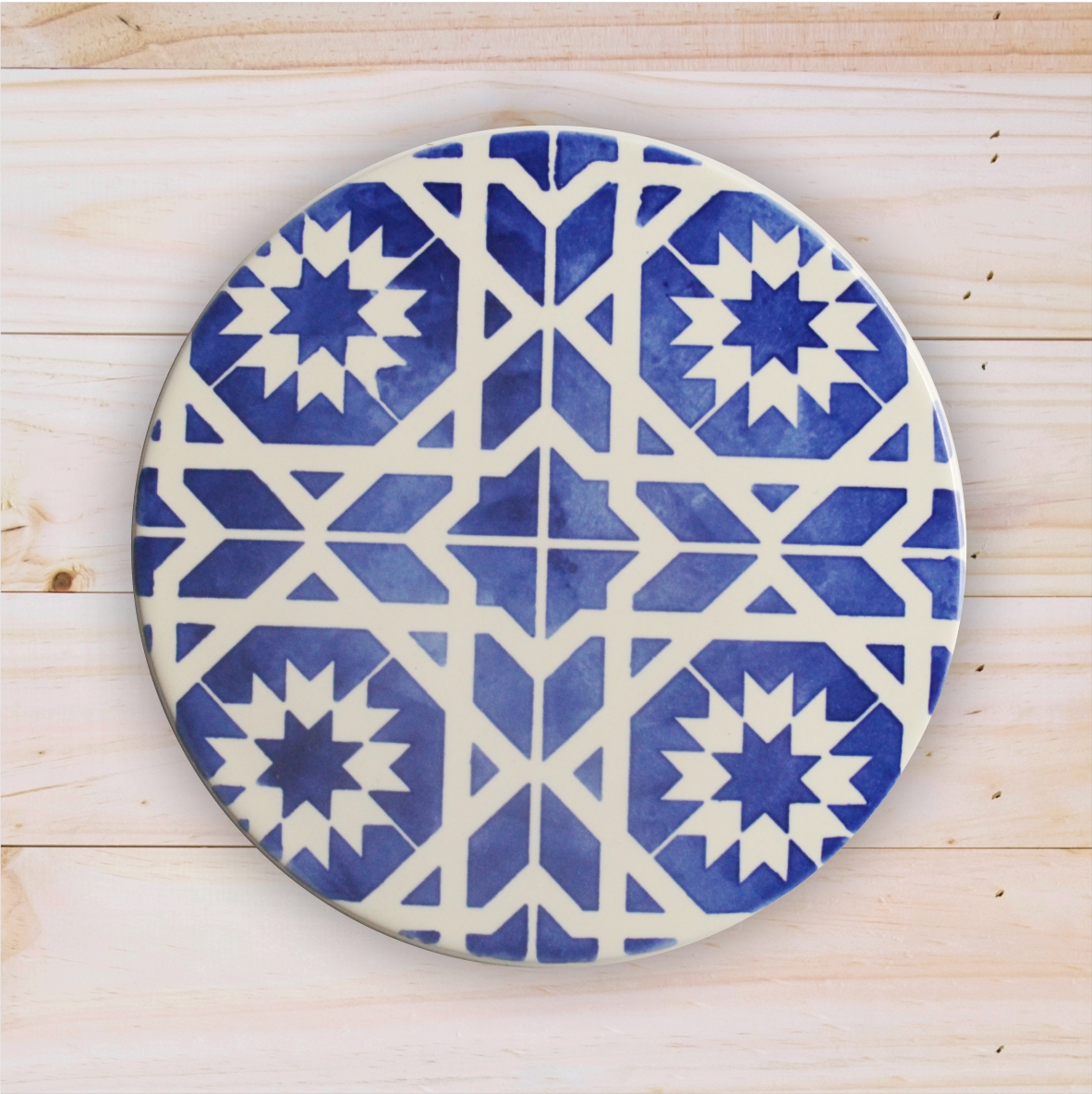 Round ceramic plate with blue and white geometric patterns on wooden surface