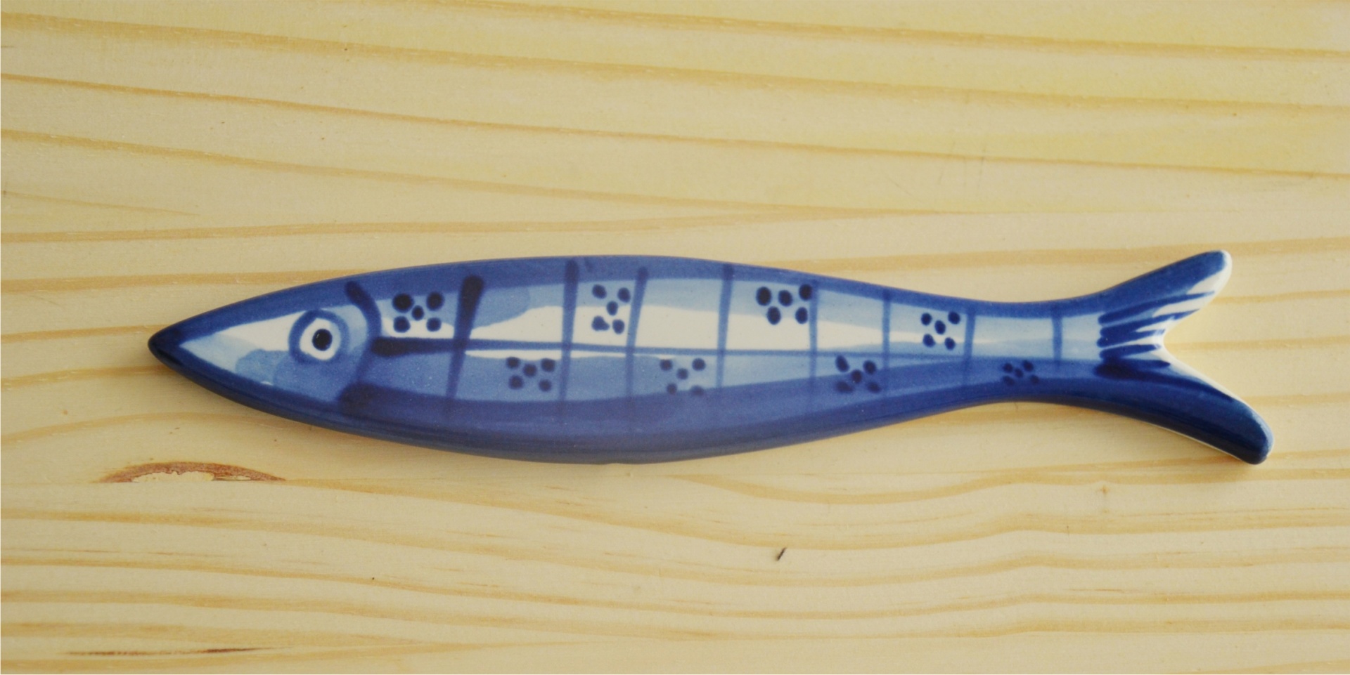 Blue and white ceramic fish on light wood