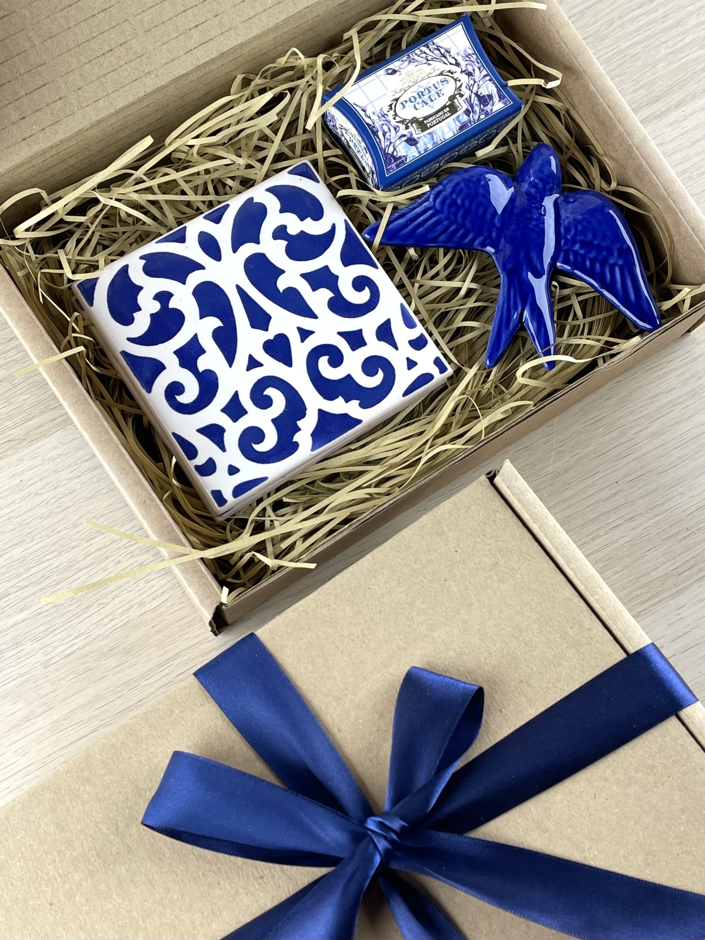 Gift box with decorative ceramic tile, ceramic bird figure, and Portuguese tile box inside.