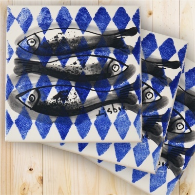 Square ceramic tiles with black fish and blue diamond pattern on white background