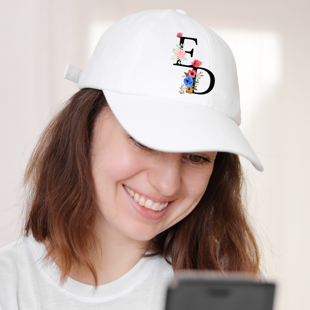 Boné branco com letras E D e flores bordadas em mulher sorridente