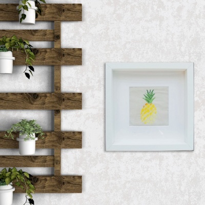 Painel de madeira com vasos de plantas e quadro branco com desenho de ananás