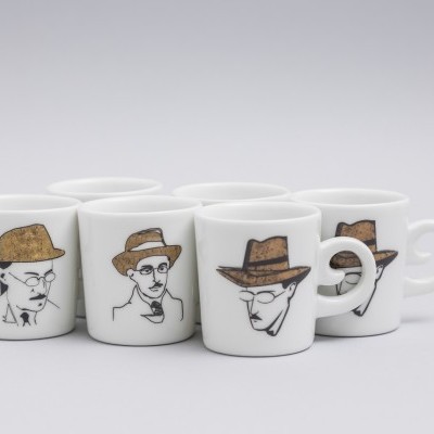 Seis canecas brancas com desenhos de caras masculinas a usar chapéus castanhos