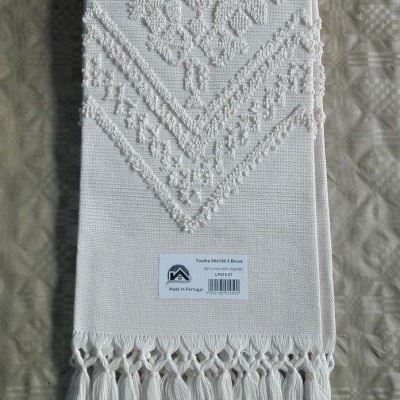 Toalha branca com bordado e franjas, etiqueta informativa visível