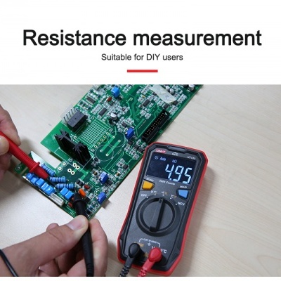 Medidor digital a medir resistência num circuito eletrónico verde