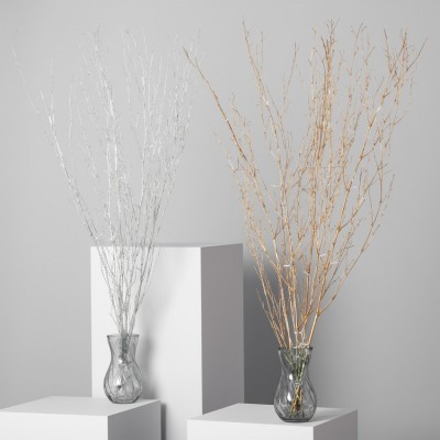 Vasos de vidro com ramos secos branco e dourado sobre bases brancas