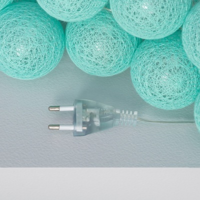 Bolas azul turquesa entrelaçadas com ficha elétrica transparente