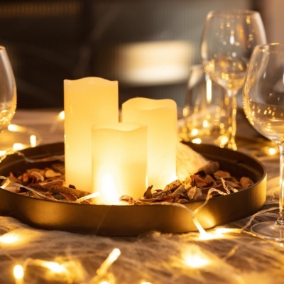 Velas LED em base preta com cascas decorativas e luzes de corda amarelas