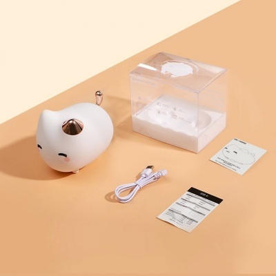 Dispositivo eletrônico em forma de gato branco com detalhes dourados, cabo USB, manual e embalagem transparente