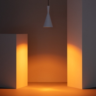 Lâmpada pendente branca cónica iluminando espaço interior com paredes e chão de tons quentes