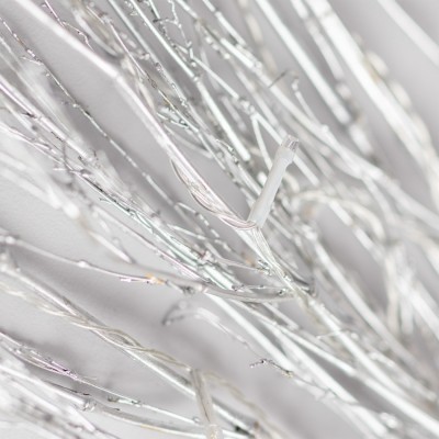 Fios metálicos prateados entrelaçados com brilho sobre fundo branco