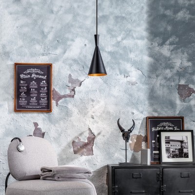 Interior com suspensão luminária negra, parede azul rústica, cadeira cinza, manta, quadro com texto e móvel preto com decoração