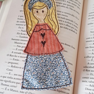 Marcador de livros em tecido bordado representando rapariga colorida