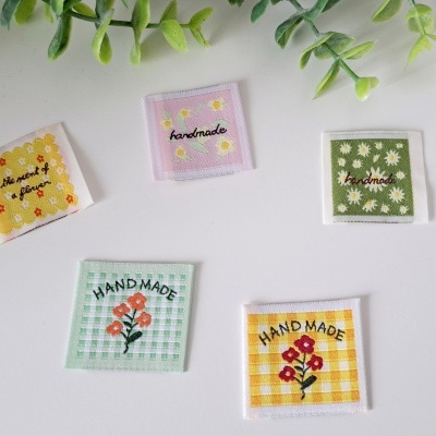 Etiquetas de tecido pequenas quadradas com padrões de flores e texto handmade