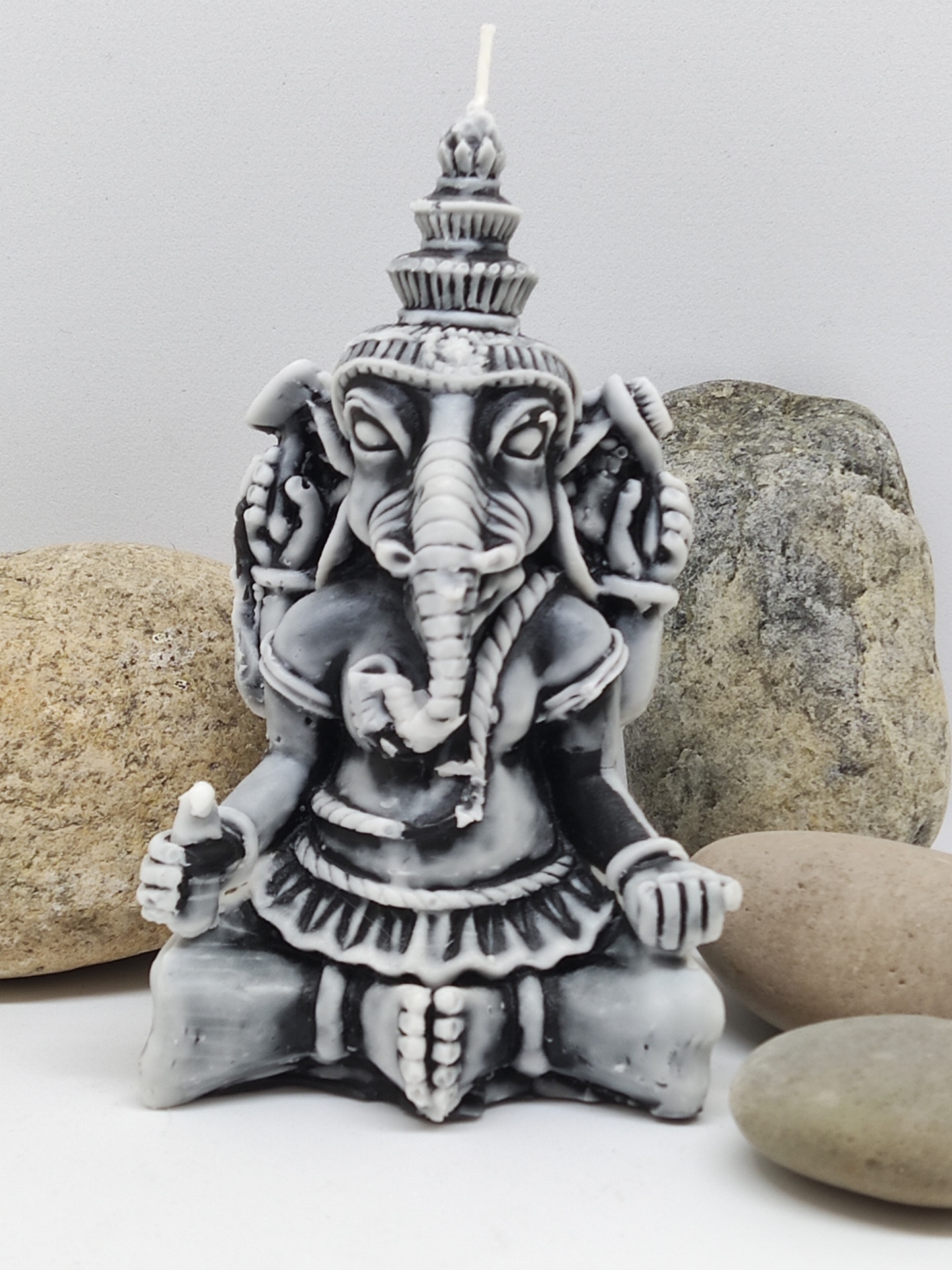 vela decorativa esculpida em forma de Ganesha com padrão cinza e preto